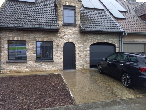 Afgeronde voordeur in PVC, modern vlak paneel met ingewerkte deurtrekker