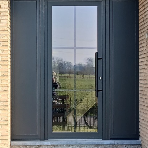 In Hasselt staat deze klassiek zwarte PVC voordeur met links en rechts vol paneel