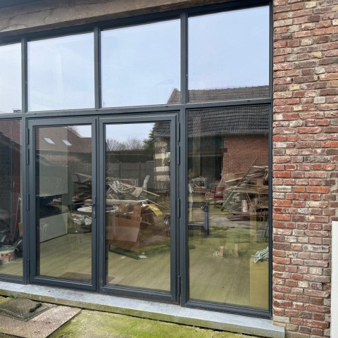 Achtergevel inkom in aluminium zwart steellook in een hoeve in Oudsbergen